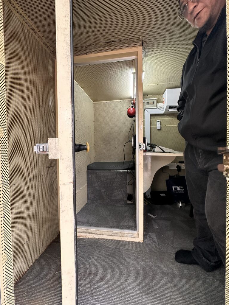 Bilik kalis bunyi untuk ujian audiometri dengan pintu terbuka dan kerusi di dalamnya