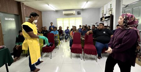 Dr. Khairimi Mohamad memerhati demonstrasi pemakaian PPE di hadapan peserta latihan THP Kota Bahagia
