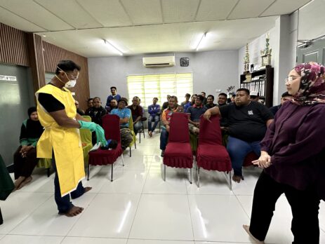 Dr. Khairimi Mohamad memerhati demonstrasi pemakaian PPE di hadapan peserta latihan THP Kota Bahagia